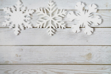 White decorative snowflakes on wooden background, copy space