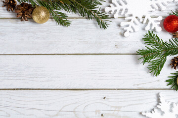 Christmas decorations on a wooden background: Christmas tree balls, branches, snowflakes and candy canes, top view, copyspace