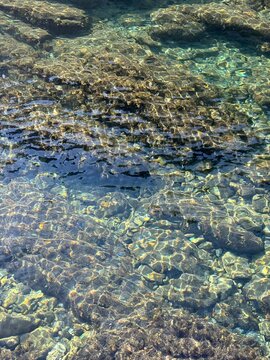 Stones and pebbles in crystal-clear water. 