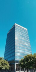 Fototapeta premium Modern office building against clear blue sky, representing professionalism and success, blue sky, business