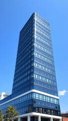 Modern office building against a clear blue sky backdrop, structure, exterior