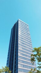 Obraz premium Modern office building towering against the clear blue sky, outdoors, building, exterior