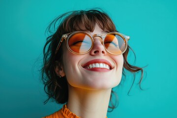 A woman wearing glasses smiles upwards, possibly showing happiness or optimism