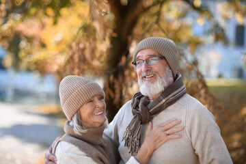 Portrait of beautiful senior couple during walk in autumn park. Elderly husband and wife are...