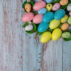 Easter background with copyspace. Colorful tulips and decorative eggs on blue wood, top view