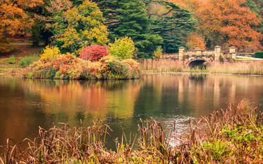Old bridge at autumn within the grounds of Ashburnham place Battle east Sussex south east England UK