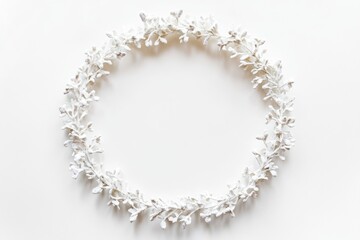 A delicate wreath made from paper flowers sits on a plain white surface