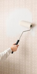Professional painter using roller to smooth freshly applied patterned wallpaper on wall, roller, painter