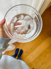 female hand holding the glass bowl with ice cubes, spa at home concept . High quality photo