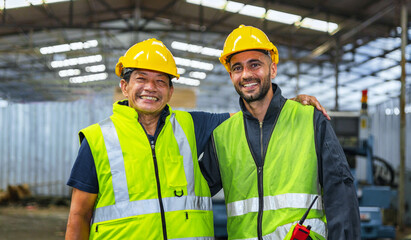 Two men wearing safety gear and smiling for the camera