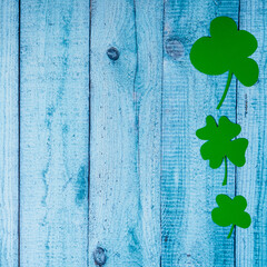 Green four leaf clovers on wooden background top view. Happy St. Patrick's Day greetings