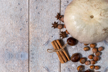Pumpkin, chestnuts, anise, cinnamon, hazelnuts on a wooden background. Top view, copy space