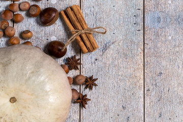 Pumpkin, chestnuts, anise, cinnamon, hazelnuts on a wooden background. Top view, copy space