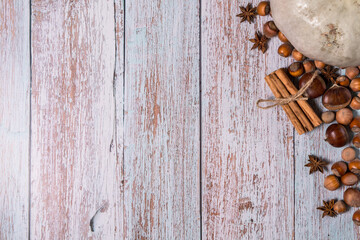 Pumpkin, chestnuts, anise, cinnamon, hazelnuts on a wooden background. Top view, copy space