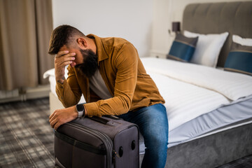 Fototapeta premium Tourist arrived in hotel room with her suitcase. He is tired of travel and needs rest.