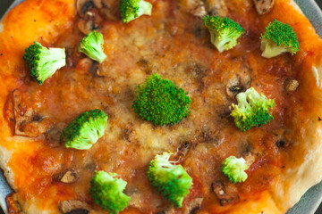 pizza with vegetables and a portrait of a baby biting pieces of pizza