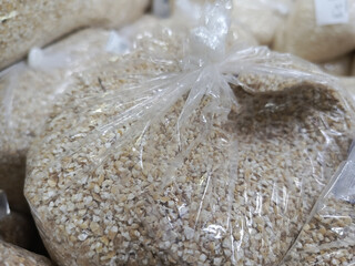 Bags with ground barley groats close-up. Barley in transparent bags. Wholesale and retail trade of groceries. Rising prices for food products.