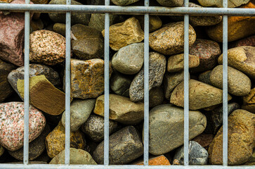 Close up of stones encased in a wire casing forming a retaining wall in the Titanic Quarter Belfast