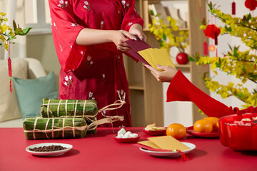 A template picture with a front view of young women wearing traditional costumes give lucky money on Lunar New Year's Day, in the living room decorated Tet traditional.