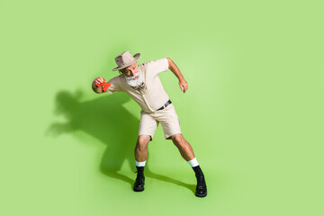 Photo of eco tourist senior man doing science exploring hold binoculars dancing isolated green color background