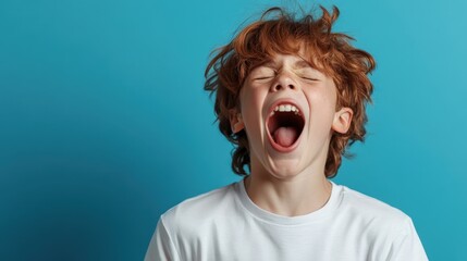 A young child with red hair exuberantly yelling, captured against a plain blue background, representing freedom of expression and the rawness of childhood emotion.
