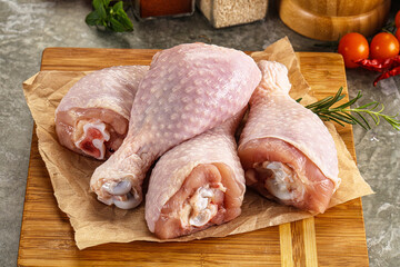 Raw uncooked chicken drumsticks over board