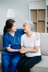 Obraz premium Asian caregiver doctor examine older patient woman therapist nurse at nursing home taking care of senior elderly woman sit on sofa.Medical service concept.