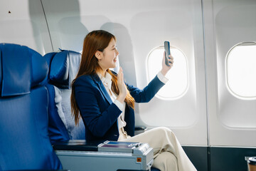 Young Asian executive excels in first class, multitasking with digital tablet, laptop and smartphone