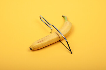 Quirky Conceptual Image of a Banana with a Hacksaw on Yellow Background - Humorous Take on Food and Tools for Creative Ideas and Unique Visual Content