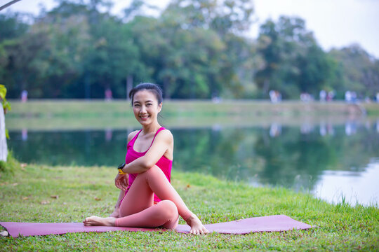 Young woman practicing yoga on soft green grass beside the lake. Young woman practicing yoga in nature. Healthy lifestyle. Concept of vitality, balance, mindfulness, Zen energy, calmness, relaxation, 