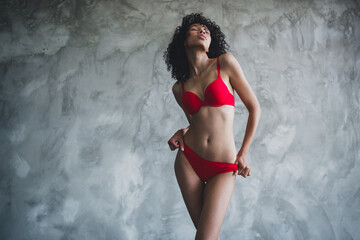 Photo of young girlfriend wearing comfortable red panties and brassiere posing her fit waist...