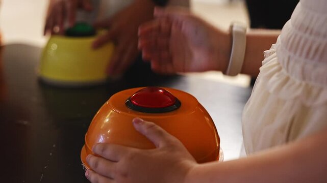 Children press buttons while playing a quiz at a party.