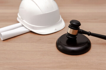 Legal concept in Construction Industry with justice Gavel and White Safety Helmet on Wooden...