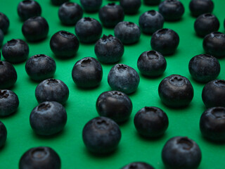 Individual blueberries on a green background are spaced apart in lines
