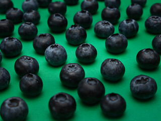 Individual blueberries on a green background are spaced apart in lines
