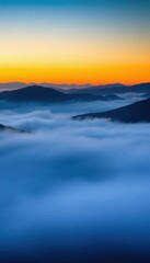 Fototapeta premium a view of a mountain range with a layer of fog in the foreground