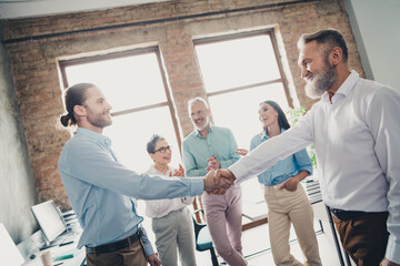 Obraz premium Photo of teamwork startup partners deal hands shake partnership comfortable nice creative startup office loft room interior