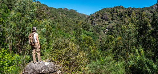 A woman enjoying the view on the lush green forest, Peneda Geres National Park in Portugal