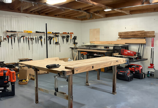 Spacious carpentry workshop with a sturdy workbench, power tools, wood planks on racks, and a rugged, lived-in feel. Generative AI
