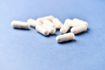 Tyrosine capsules (one of the 20 standard amino acids). A dietary supplement used to improve attention and focus on paper background. Soft focus. Close up.