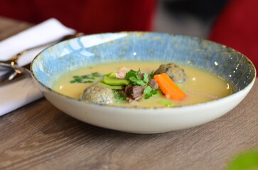 close view of traditional Czech food, Kaldoun goose soup, served food on a plate in a restaurant, wooden table, Saint Martin's goose, traditional Czech holiday food