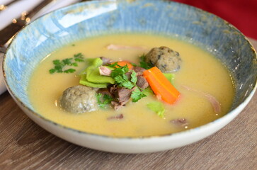 close view of traditional Czech food, Kaldoun goose soup, served food on a plate in a restaurant, wooden table, Saint Martin's goose, traditional Czech holiday food