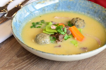 close view of traditional Czech food, Kaldoun goose soup, served food on a plate in a restaurant, wooden table, Saint Martin's goose, traditional Czech holiday food