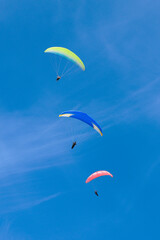 Paraglider flying in the air over hills. Aerial view of flying on a sunny day. 
