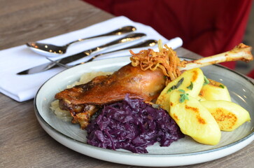 Czech food goose with blue cabbage and potato dumplings, served food on the table in a restaurant