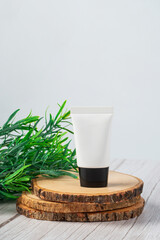 Plastic white tube for cream or lotion. Skin care or sunscreen cosmetic on white wood background.