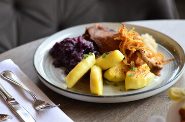 The deep purple of the red cabbage contrasts with the crispy, golden-brown potato pancakes and the succulent, slow-cooked duck meat