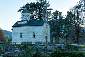 A serene stone church surrounded by nature, suitable for travel brochures, religious events, or autumn-themed designs.