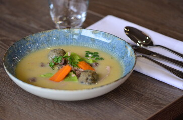 close view of traditional Czech food, Kaldoun goose soup, served food on a plate in a restaurant, wooden table, Saint Martin's goose, traditional Czech holiday food