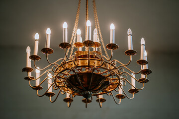 Elegant close-up of a classic chandelier with lit candles, intricate golden design, and warm glow,...